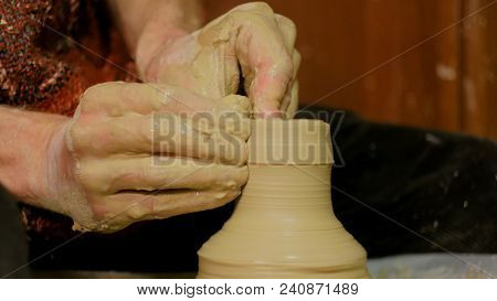 Professional Male Potter Making Ceramics In Workshop