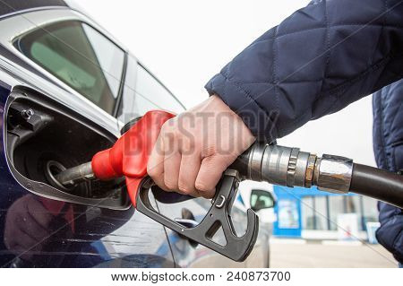 Hand Pumping Gasoline With Refueling Gun At Gas Station