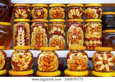 Beautifully Decorated Honey With Nuts And Cans On The Market