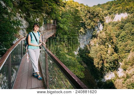 Zeda-gordi, Georgia. Beautiful Woman Posing For Photo On Narrow Suspension Bridge Or Pendant Road Up
