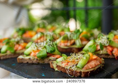 Appetizer Canape With Shrimp And Cucumber On Plate On Table In The Restaurant. Close Up