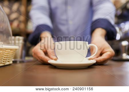 Photo of barist man with cup of coffee