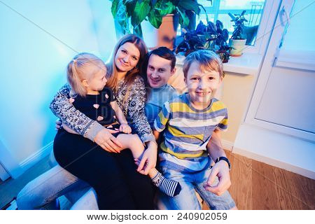 Parents And Kids Sitting On The Sofa And Having Fun At Home. Smiling A Lot Close Up