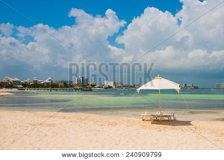 Sun Loungers And A White Umbrellas For Tourists On The Beach In Cancun. Mexico.