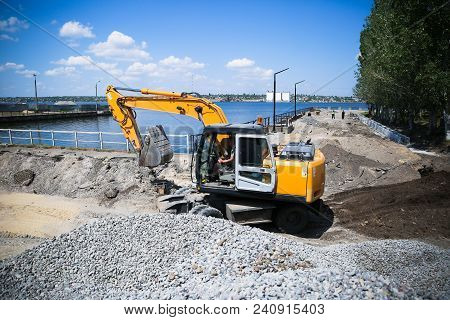 Big Excavator On New Construction Site. Excavator Loader Machine During Earthmoving Works Outdoors A