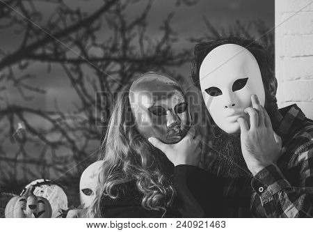 Girl And Man Hide Face With Masque. Woman With Long Blond Hair And Bearded Hipster In Mask At Window
