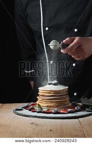 Serving Pancakes With Powdered Sugar And Berries. Chef Woman Hand. Beautiful Food Still Life. Slight