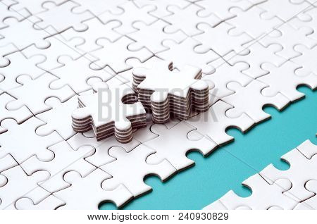 The Blue Path Is Laid On The Platform Of A White Folded Jigsaw Puzzle. The Missing Elements Of The P