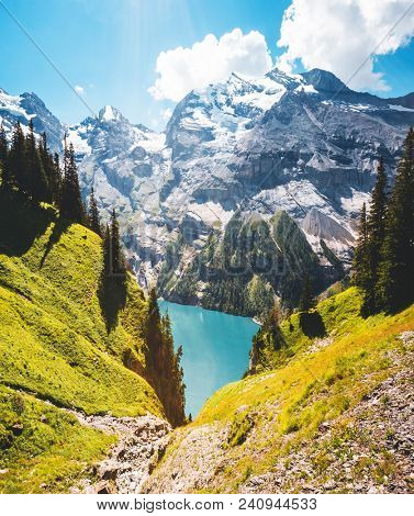 Idyllic panorama view of the azure lake Oeschinensee. Location place Swiss alps, Kandersteg, Bernese Oberland, Europe. Scenic image of most popular tourist attraction. Discover the beauty of earth.