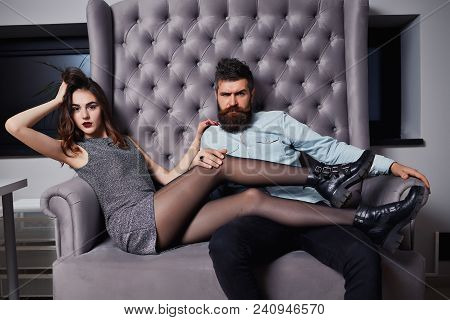 Young Fashion Couple Having Problems Between Each Other. Beautiful Couple Sitting On The Couch And L