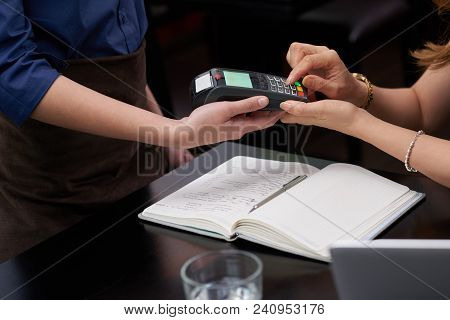 Close-up Image Of Woman Entering Pin Code To Pay In Restaurant