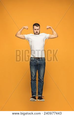 Symbol Of Strength And Muscles. Mid-air Shot Of Handsome Happy Young Man Jumping And Gesturing Again