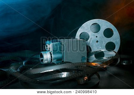 8 Mm Movie Camera With A Reel Of Film In Smoke. Dark Background