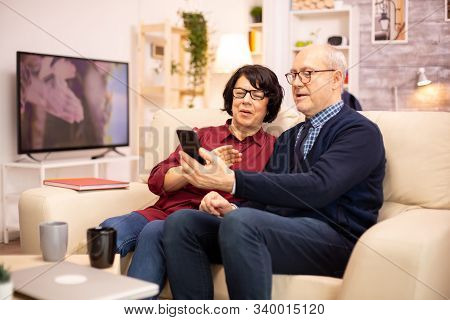 Old Eldelry Couple Using A Smartphone To Talk With Their Family