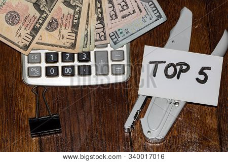 Dollars On Calculator And White Label With Text Top 5 On It.