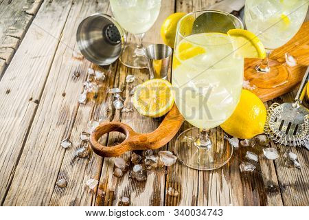 Trendy Summer Cold Drink. St Germain French Spritz Cocktail With Lemon Slices, Old Rustic Wooden Bac
