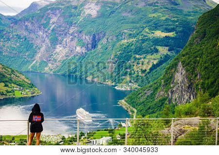 Tourist Wearing Norwegian Flag Clothing Enjoying Scenic View Over Fjord Geirangerfjorden From Flydal