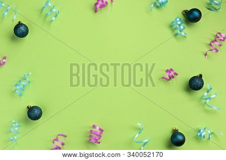 Christmas, New Year, Winter Concept. Colorful Serpentine And Balls, On Green  Background. Flat Lay, 