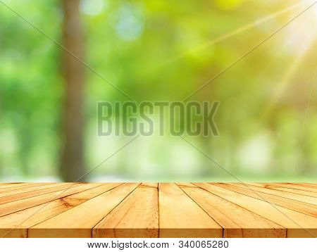 Wooden Table With A Backdrop Of Natural Green Bokeh