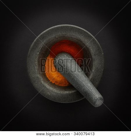 Plan View Of Pestle & Morter And Ground Spices, Shot On A Dark Background, With Space For Copy