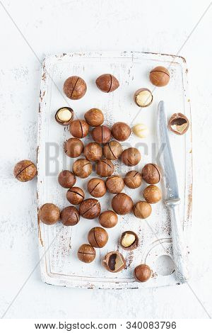 Plate With Almonds In Endocarp, Whole And Chopped Open Nuts In Bulk On A Cutting Board With Knife On