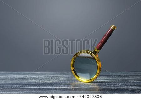 People Look At A Huge Magnifying Glass. Search And Analysis, Analytics And Study. Pay Attention To D