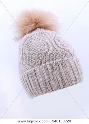 Beige Wool Knit Ski Hat With Faux Fur Pompom Isolated On White. Bobble Hat Topped With Pom Pom Or Lo