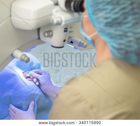 Ophthalmologist Surgeon At The Modern Laser Eye Surgery Apparatus. Close Up Doctor Treats Cataract T