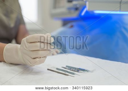 Close-up Of An Ophthalmologist Doctor Holding Instruments For Microscopic Eye Surgery In His Hand Ov