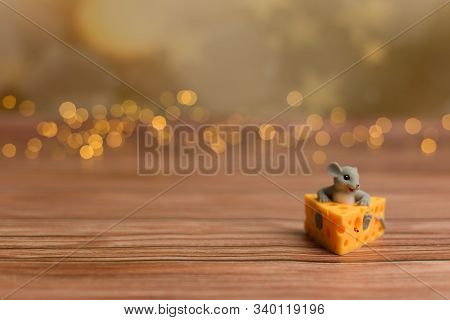 A Toy Mouse Sits In Cheese On A Wooden Starry Background, A Symbol Of 2020.