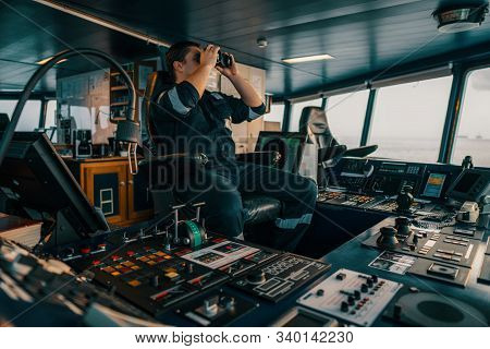 Navigational Officer Lookout On Navigation Watch Looking Through Binoculars. Marine Industry. Colreg