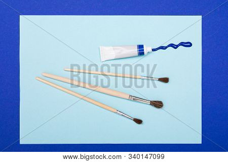 Drawing Set Sach As Brushes, Note, Scetchbook, Paints, Oil And Cup Of Coffee Isolated On Blue Backgr
