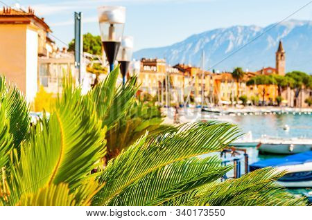 Garda Lake Western Shore, Lombardy Italy. View On Medieval Toscolano Maderno Cityscape Through Palm 