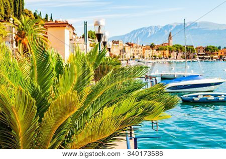 Garda Lake Western Shore, Lombardy Italy. View On Medieval Toscolano Maderno Cityscape Through Palm 