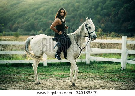 Full Length Of Young Handsome Man Sitting On His White Stallion At The Country Side. Man Equestrian 