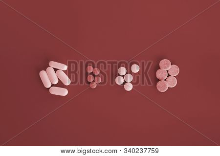 Different Pills On Bloody Red Background. Top View Medicine Concept.