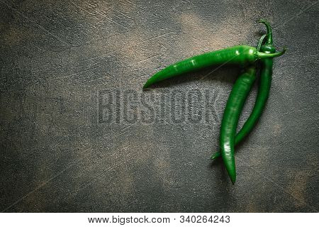 Green Chilli Peppers On A Dark Background With Copy Space