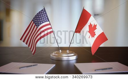 Usa And Canada Flags On Table. Negotiation And Partnership Concept. 3d Rendered Illustration.