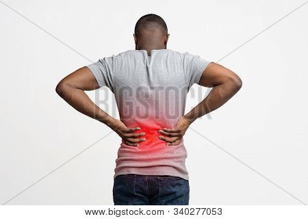 Afro Guy Holding Both Hands Behind His Back, Pain In Spine, Inflamed Zone Highlighted In Red, White 