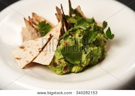 Guacamole With Pita Chips On White Plate. Chef's Signature Dish