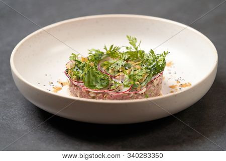 Fresh Beef Tartare Dish With Fresh Vegetables In White Plate