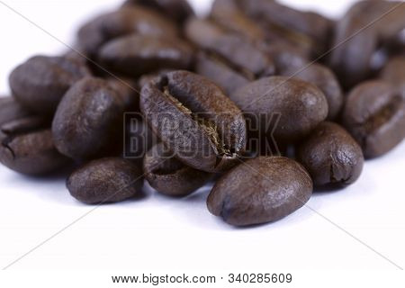 A Group Of Freshly Roasted Coffee Beans On A White Background.close-up, Horizontal, Macro, Place For