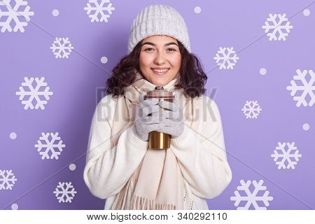 Studio Shot Of Happy Smiling Girl Dresses White Warm Winter Clothes, Holding Stylish Thermo Mug And 