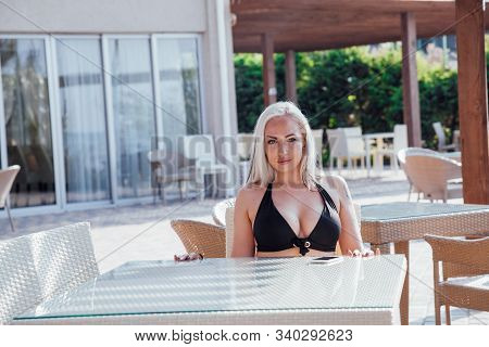 Blonde Girl Sitting At The Beach Restaurant