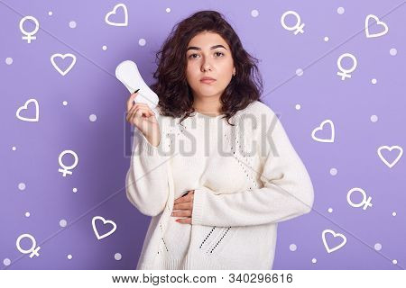 Photo Of Upset Unsatisfied Young Lady Putting One Hand On Stomach, Having Stomache During Critical D