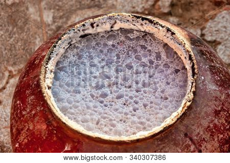brewing traditional African beer, in a ceramic pot, the beverage already fermenting