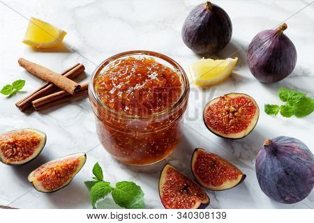 Fresh Figs, With A Dish Of Homemade Fig Jam Or Preserves Marmalade Kitchen Marble Table Background.