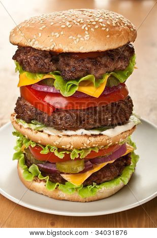 огромные вкусные двойной чизбургер на тарелке
