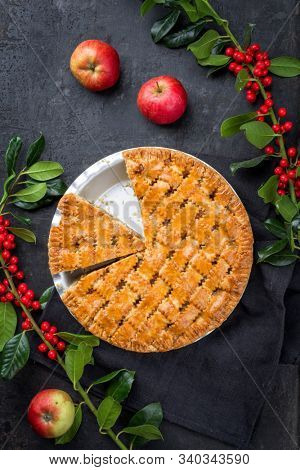 Traditional apple jalousie cake offered as top view in a backing form with decoration on a black board