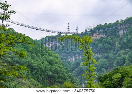 A Gorge In The Mountains With A Suspension Bridge Over It. Skybridge Suspension Bridge Over A Precip